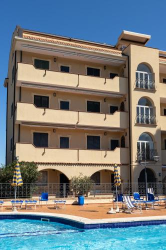 a hotel with a swimming pool and a building at Residence Vigna del Mare in Gabicce Mare