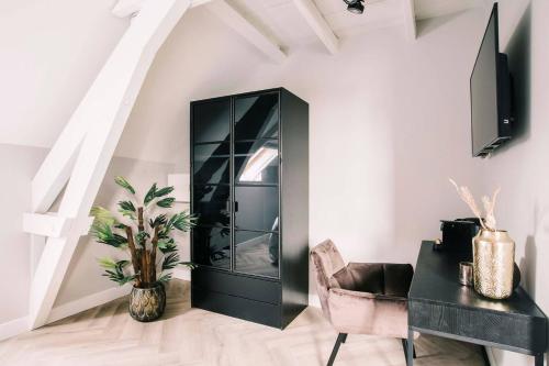 a black cabinet in a room with a chair and a table at HotelBed w aircon at City Villa Tilburg Willem 1 in Tilburg