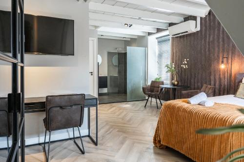 a bedroom with a bed and a table and a kitchen at HotelBed w aircon at City Villa Tilburg Willem 1 in Tilburg
