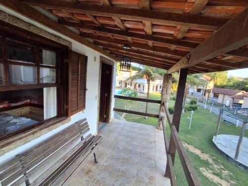 an outside porch of a house with a bench at Pousada Nova Conquista in Penedo
