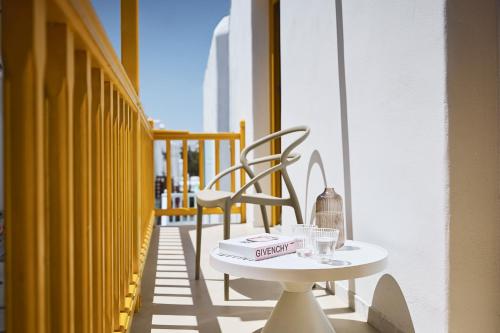 a table with a book on it on a balcony at Elaia Luxury Suites Mykonos in Mýkonos City