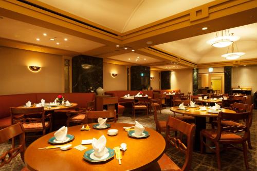 a restaurant with tables and chairs with hats on them at Urayasu Brighton Hotel Tokyo Bay in Urayasu