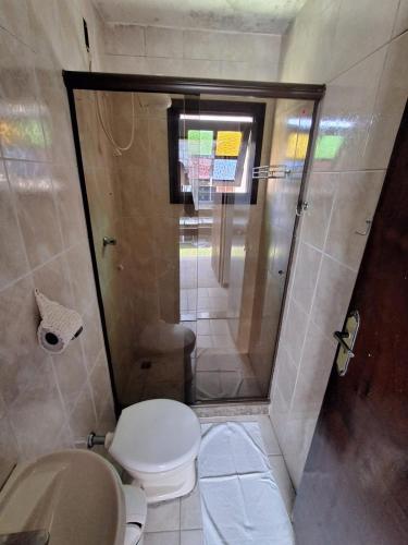 a small bathroom with a toilet and a shower at Pousada Nova Conquista in Penedo