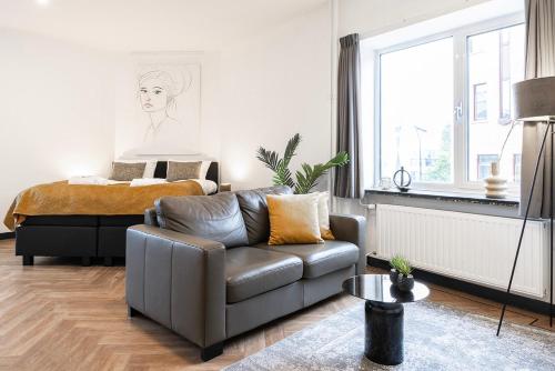 a living room with a couch and a bed at Spacious City Loft With Balcony & High-speed Wi-fi in Tilburg