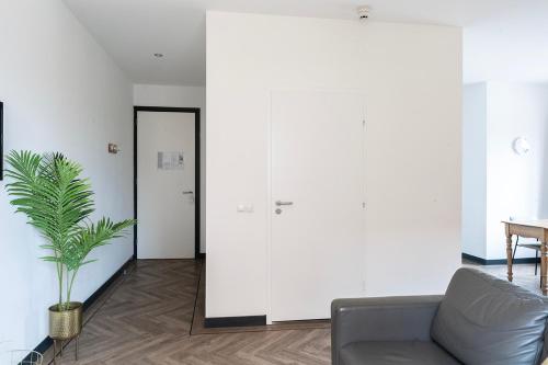 a living room with a couch and a plant at Spacious City Loft With Balcony & High-speed Wi-fi in Tilburg