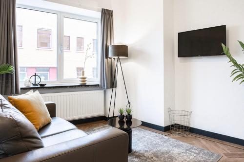 a living room with a couch and a window at Spacious City Loft With Balcony & High-speed Wi-fi in Tilburg