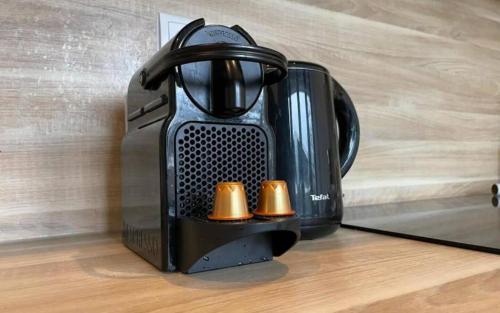 a black coffee maker sitting on a wooden floor at Spacious City Loft With Balcony & High-speed Wi-fi in Tilburg