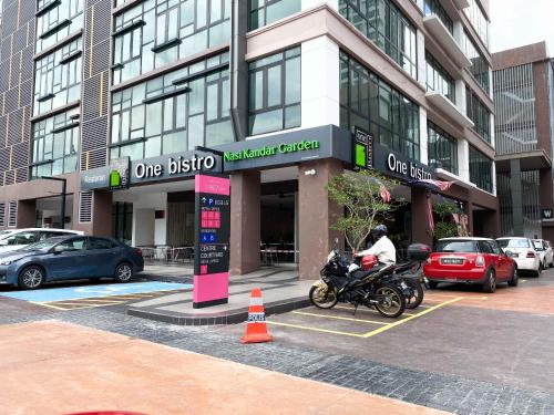 a man riding a motorcycle in front of a building at The Icon6 Condo in IOI City Mall Putrajaya, Pool View in Putrajaya