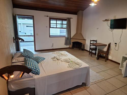 a bedroom with a bed in a room with a fireplace at Pousada Nova Conquista in Penedo