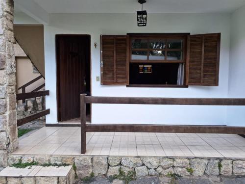 a bench in front of a house with a window at Pousada Nova Conquista in Penedo
