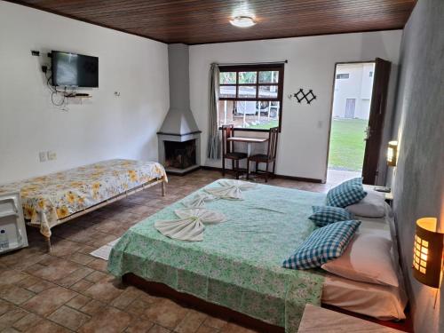 a bedroom with a bed and a fireplace and a tv at Pousada Nova Conquista in Penedo