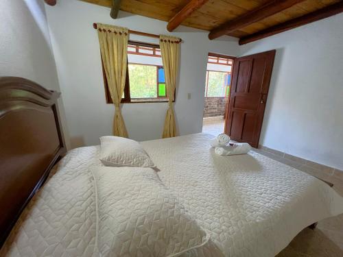 ein großes weißes Bett in einem Zimmer mit Fenster in der Unterkunft CASA VACACIONAL SAN MARCOS in Villa de Leyva