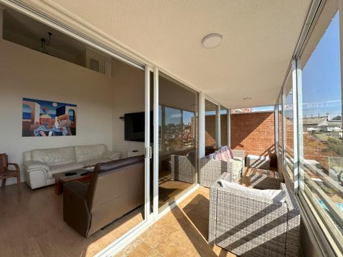 a living room with a couch and a tv at Exclusive Duplex apartment in Viña del Mar