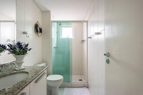 a bathroom with a shower and a toilet and a sink at Lindo Apto no Terraços da Rainha in Balneário Camboriú