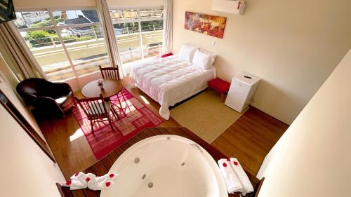 a bathroom with a bed and a tub in a room at Hotel Casa Redonda Boutique Spa in Campos do Jordão