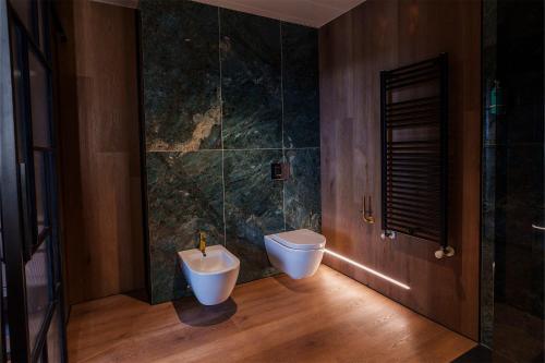a bathroom with a toilet and a bath tub at Spirit Hotel Ciudad de Burgos in Rubena