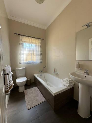a bathroom with a tub and a toilet and a sink at Radiant 2BED penthouse Mellieha!! by Homely in Ix-Xagħra taʼ Barra
