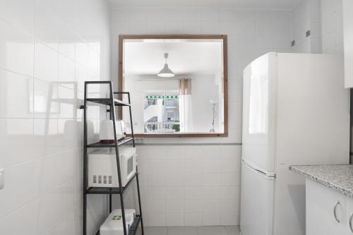 a kitchen with a white refrigerator and a ladder at Casa Aragon Conil in Conil de la Frontera