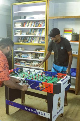 two men standing in front of a foosball table at Summer Hostel in Palolem
