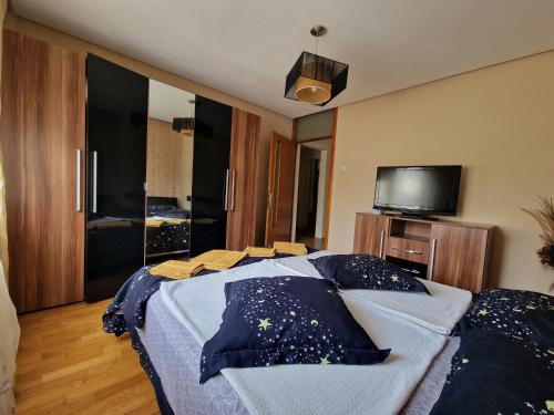 a bedroom with a bed with blue sheets and a tv at Apartment Central in Constanţa
