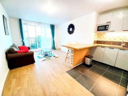 a kitchen and living room with a couch and a table at Melody Clamart, 25 min de Paris, Tramway 6, Parking in Clamart