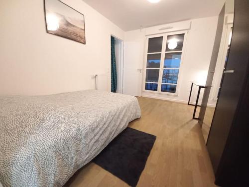 a white bedroom with a bed and a window at Melody Clamart, 25 min de Paris, Tramway 6, Parking in Clamart