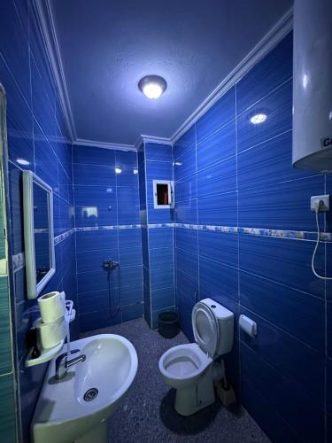 a blue bathroom with a toilet and a sink at Casa Sharawy in Chefchaouen