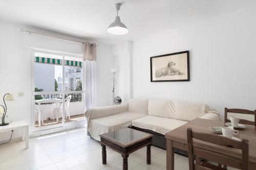 a living room with a white couch and a table at Casa Aragon Conil in Conil de la Frontera