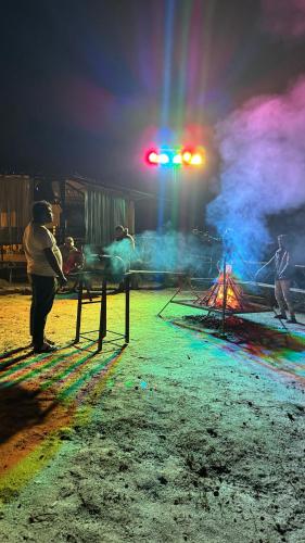 a group of people standing around a tent at night at Hazy Mount Vattavada in Kottakamboor