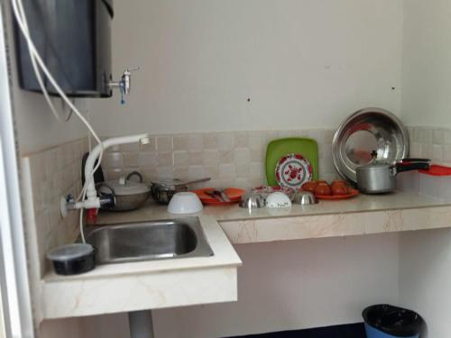a kitchen counter with a sink and some pots and pans at Panchalaya Homestay in Guwahati