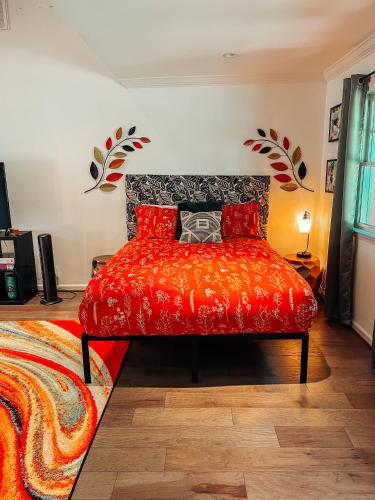 a bedroom with a red bed with red pillows at Cozy Guest House Studio Apartment in Greensboro