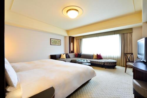 a hotel room with a large bed and a couch at Urayasu Brighton Hotel Tokyo Bay in Urayasu