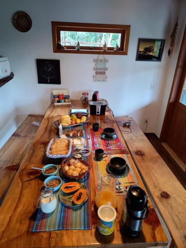een houten tafel met eten erop bij Casa da Lua Estrela in Visconde De Maua