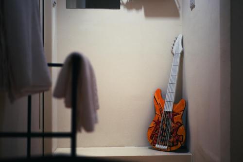 a guitar hanging on a wall in a room at 東海平行陸貳民宿English Friendly in Longjing