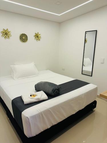 a white bedroom with a large bed with a mirror at Aero Hotel Boutique in Bogotá