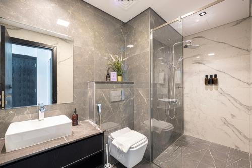 a bathroom with a sink and a shower at Brand New 1BR with Pool, Sauna & Gym in Dubai