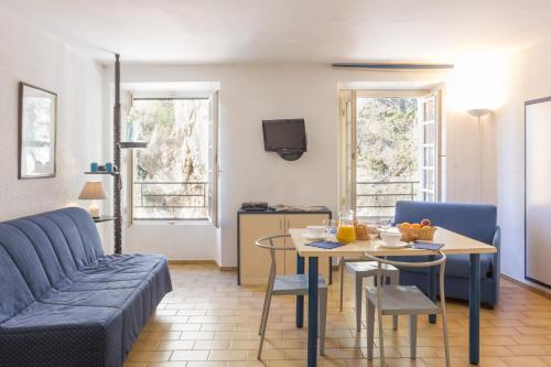 un salon avec un canapé et une table dans l'établissement Résidence Partenaire Le Palais de la Marine, à Villefranche-sur-Mer