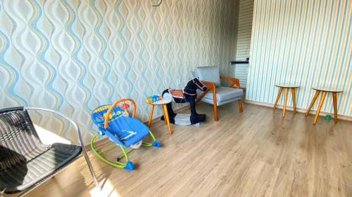a living room with a chair and a table and chairs at Hotel Capital da Fe in Aparecida