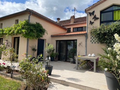 a house with a patio and a table in front of it at Favau in Villeneuve-sur-Lot
