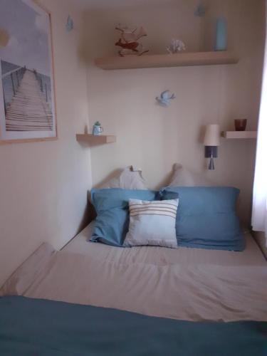 une chambre avec un lit avec des oreillers bleus et blancs dans l'établissement Brin d'azur, à Saint-Raphaël