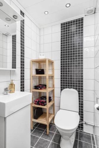 a white bathroom with a toilet and a sink at Villa Veranda in Linköping