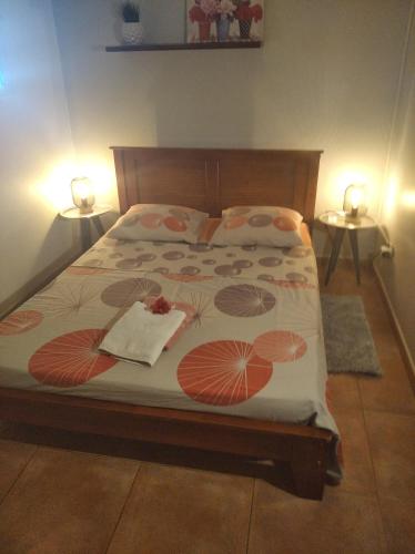 a bedroom with a bed with two tables and two lamps at ChezRoselineetChritian in Les Avirons