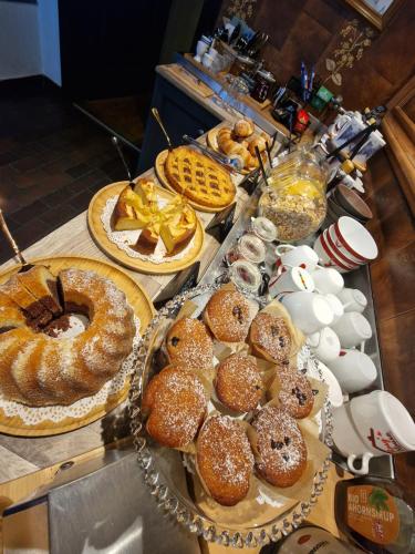 a table topped with different types of pastries and pies at Rosy's House B&B in Bad Goisern