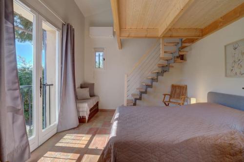 une chambre avec un lit et un escalier en colimaçon dans l'établissement VILLA rénovée, piscine vue mer, clim, borne VE, à Roquebrune-sur Argens
