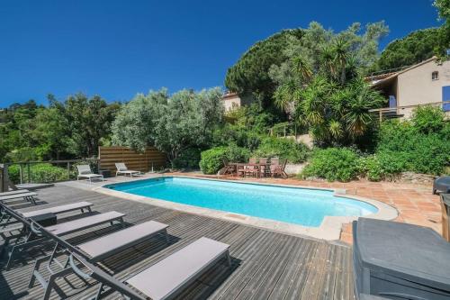 - une piscine avec des chaises longues à côté d'une maison dans l'établissement VILLA rénovée, piscine vue mer, clim, borne VE, à Roquebrune-sur Argens