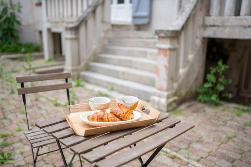 une table en bois avec une assiette de nourriture dessus dans l'établissement Appartement 21 - Lumineux - Paisible - Proximité Lac et Parcs, à Vichy