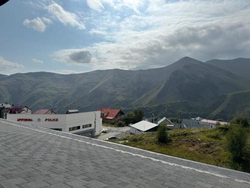 a view of a mountain with a building and mountains at Marshall Gudauri Apartment in Gudauri