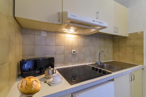una cocina con fregadero y una barra de pan. en Résidence Partenaire Le Palais de la Marine, en Villefranche-sur-Mer