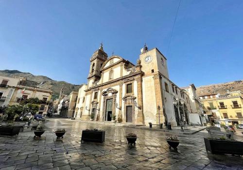 an old building with a clock tower on a street at LA CASTELLANA Apartments in Carini