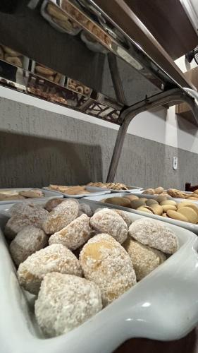 a bunch of donuts on a tray in a bakery at Hotel Capital da Fe in Aparecida